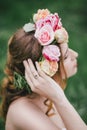 Beautiful bride in a wedding dress with bouquet and roses wreath posing in a green garden Royalty Free Stock Photo