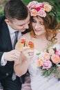 Beautiful bride in a wedding dress with bouquet and roses wreath posing with groom wearing wedding suit Royalty Free Stock Photo