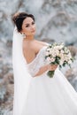 Beautiful bride in a wedding dress with a bouquet on the top of the salt mountains. A stunning young bride with curly hair .