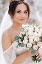 Beautiful bride in a wedding dress with a bouquet on the top of the salt mountains. A stunning young bride with curly hair .