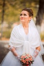 Beautiful bride in wedding dress and bridal bouquet, happy newlywed woman with wedding flowers, woman with wedding makeup and hair Royalty Free Stock Photo