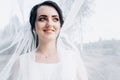 Beautiful bride in a wedding dress covered with a veil. Portrait of the bride in nature under a veil Royalty Free Stock Photo