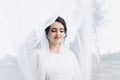 Beautiful bride in a wedding dress covered with a veil. Portrait of the bride in nature under a veil Royalty Free Stock Photo