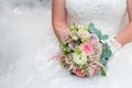 Beautiful bride in a wedding dress holding a bouquet of pink roses. White background. Royalty Free Stock Photo