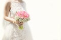 Beautiful bride in a wedding dress holding a bouquet of pink tulips. White background. Royalty Free Stock Photo