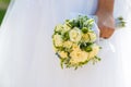 Beautiful bride in a wedding dress holding a bouquet of yellow roses. White background. Royalty Free Stock Photo