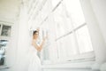 Beautiful bride in wedding dress with long full skirt, white background, dance and smile Royalty Free Stock Photo