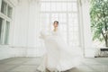 Beautiful bride in wedding dress with long full skirt, white background, dance and smile Royalty Free Stock Photo