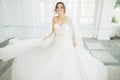 Beautiful bride in wedding dress with long full skirt, white background, dance and smile Royalty Free Stock Photo