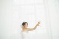 Beautiful bride in wedding dress with long full skirt, white background, dance and smile Royalty Free Stock Photo