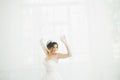 Beautiful bride in wedding dress with long full skirt, white background, dance and smile