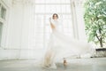 Beautiful bride in wedding dress with long full skirt, white background, dance and smile Royalty Free Stock Photo