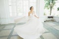 Beautiful bride in wedding dress with long full skirt, white background, dance and smile Royalty Free Stock Photo