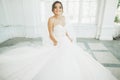 Beautiful bride in wedding dress with long full skirt, white background, dance and smile Royalty Free Stock Photo
