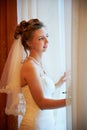 Beautiful bride in wedding dress near window Royalty Free Stock Photo