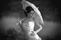 Beautiful bride in wedding dress with umbrella, outdoors portrait. Black and white Royalty Free Stock Photo
