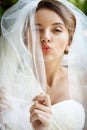 Beautiful bride in wedding dress and veil winking, sending kiss. Royalty Free Stock Photo