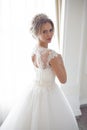 Beautiful bride in a wedding dress in white interior