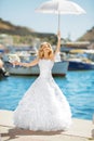 Beautiful bride in wedding dress with white umbrella posing over Royalty Free Stock Photo