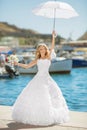 Beautiful bride in wedding dress with white umbrella posing over Royalty Free Stock Photo