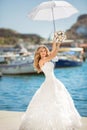 Beautiful bride in wedding dress with white umbrella posing over Royalty Free Stock Photo