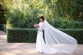 Beautiful bride in a wedding white dress , a long veil in her hair, bouquet of flowers in her hands Royalty Free Stock Photo