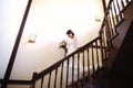 Beautiful bride in a white dress with a bouquet of flowers in her hands goes down the stairs Royalty Free Stock Photo