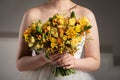 Bride in white dress with bouquet in photostudio