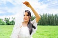 Beautiful bride in white dress and flowing vail in forest location  sunny park on a cloudy day Royalty Free Stock Photo