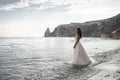 Beautiful bride in white dress posing on sea and mountains in background Royalty Free Stock Photo