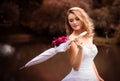 Beautiful bride in white dress with an umbrella, park Royalty Free Stock Photo