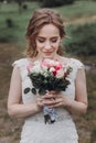 Beautiful bride in white wedding dress holding bouquet and smiling, gorgeous newlywed bride posing outdoors with flowers, bridal Royalty Free Stock Photo