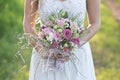 Beautiful bride in white wedding dress holding a bridal bouquet. Royalty Free Stock Photo