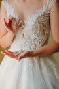 Beautiful bride in white wedding dress puts on earring. Beauty model girl is wearing jewelry. Female portrait in bridal gown for Royalty Free Stock Photo