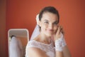 Beautiful bride in white wedding dress puts on earring Royalty Free Stock Photo