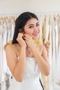 Beautiful bride in white wedding dress puts on earring in wedding studio Royalty Free Stock Photo