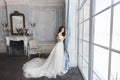 Beautiful bride, young model brunette woman, in stylish wedding dress with naked shoulders, with bouquet of flowers in Royalty Free Stock Photo