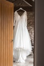 Beautiful brides wedding dress hanging in barns from wooden beams Royalty Free Stock Photo