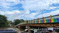 Beautiful bridge with rainbow colored paint over the Martapura river with boats anchored in the city of Banjarmasin