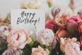 bright bouquet of colorful roses with white card with the inscription happy birthday, concept of congratulations Royalty Free Stock Photo