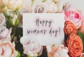 bright bouquet of colorful roses with white card with the inscription happy women s day  concept of congratulations on Royalty Free Stock Photo