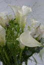 A beautiful, bright bouquet, a composition of white calla lilies, purple white orchids, flowers with green leaves, branches. Royalty Free Stock Photo