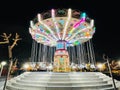 Beautiful bright carousel in park at night in winter in Tirana city. Royalty Free Stock Photo