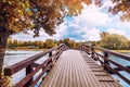 Beautiful bright colorful autumn landscape, a wooden bridge across the lake river in the forest Royalty Free Stock Photo