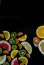 Beautiful bright delicious juicy pieces of citrus fruit on black background vertically from the bottom with copyspace