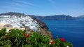 Beautiful bright panoramic view of Oia in Santorini - the white buildings, the bright sea and beautiful plants in the foreground Royalty Free Stock Photo
