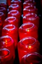 Beautiful bright red glass prayer candles lined up in rows. Royalty Free Stock Photo