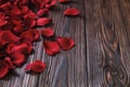 Beautiful bright red rose petals on wooden background. Happy valentines day oliday sales concept. Royalty Free Stock Photo