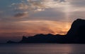 Beautiful bright sunset on the Black Sea in the Sudak. Seaside with outline of cape Kapchik. Crimea landscape. Royalty Free Stock Photo