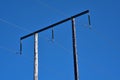 Beautiful bright view of overhead electrical power lines on old wooden pillar captured against perfectly clear blue sky Royalty Free Stock Photo